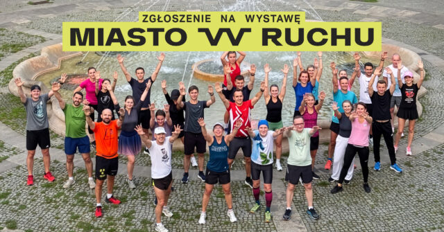 Grupa ludzi w kolorowych, sportowych ubraniach podnosi ręce do góry na tle fontanny miejskiej.